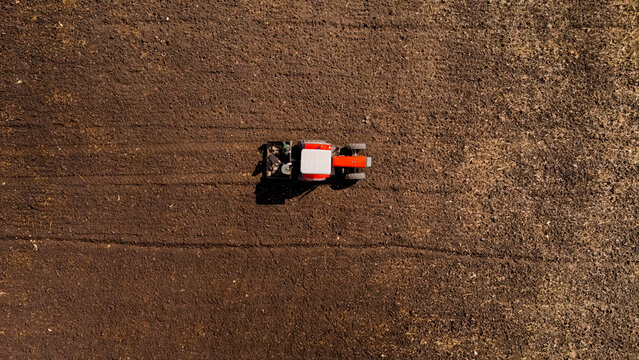 Top view of a tractor with farmers cleaning a field in Michoacan, Mexico