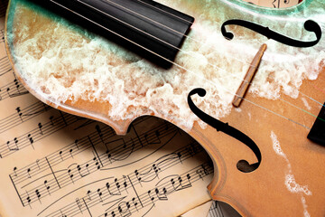 Violin on music sheets, closeup. Musical instrument and seascape, double exposure