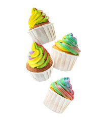 Yummy cupcakes with bright rainbow cream in air on white background