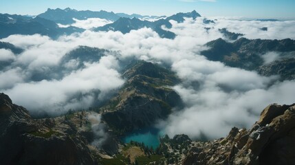 A stunning landscape view of a lake amidst mountains shrouded in clouds.