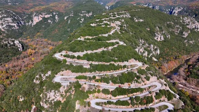 Drone shot of Cars driving over an impressive hairpin roud in the mountains
