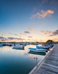 Fototapeta premium Boats Bobbing Quietly in a Harbor Under a Fading Evening Sky