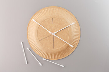 A paper plate with cotton swabs arranged on it, forming a snowflake design. Step in DIY crafting...
