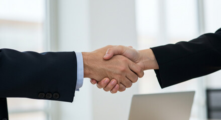 Obraz premium A powerful handshake sealing a significant business deal, symbolizing trust and collaboration in a modern office setting with neutral light.