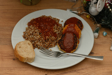 Delicious homemade meal featuring savory meat patties and hearty buckwheat served on a cozy wooden table