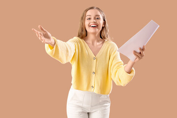 Beautiful actress with film script on beige background