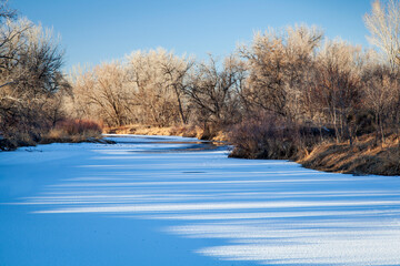 frozen Cache la Poudre River in Fort Collins, Colorado with shadow patterns on ice