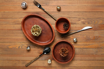 Beautiful table setting with Christmas balls and pine cones on wooden background