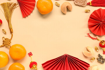 Frame made of fortune cookies with mandarins and Chinese symbols on beige background. New Year...
