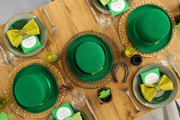 Festive table serving with leprechaun's hats, horseshoe and clovers, top view. St. Patrick's Day...
