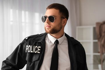 Male police officer wearing uniform indoors