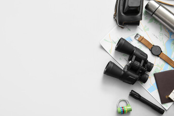 Binoculars and travel items on white background