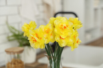 Beautiful bouquet of daffodils in kitchen, closeup