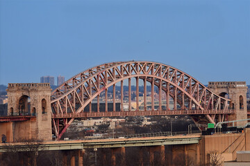 Iconic Hell Gate Bridge in New York City, a historic steel arch railroad bridge spanning the East River. 