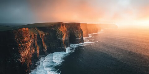 A breathtaking view of cliffs meeting the ocean during a dramatic sunset.