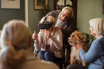 Senior woman in wheelchair using vr headset with friends at home