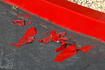 curb painted red and chipped paint on street