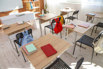 Interior of empty classroom with desks and backpacks