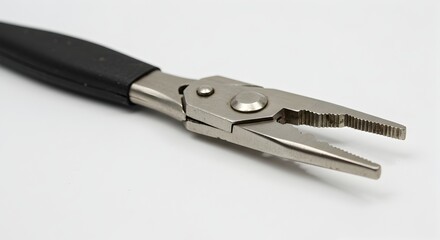 Obraz premium Close-up of silver pliers with a black handle showcasing its serrated jaws and rivet details on a white background.