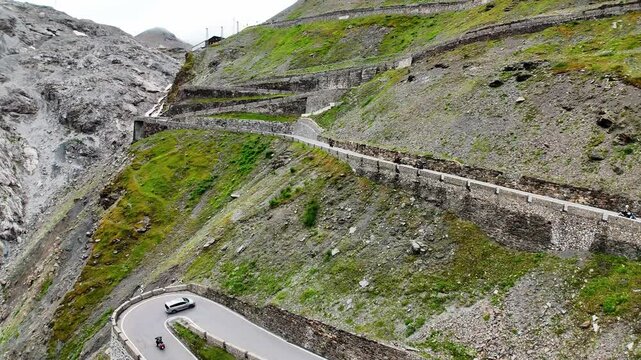 Drone shot of motorcycles driving over the Prato allo Stelvio Pass, Italy