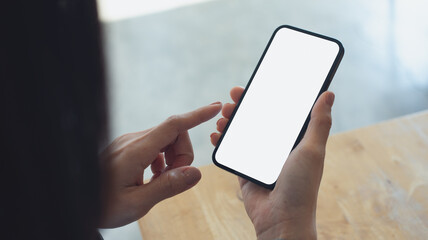Mockup, blank screen cell phone. Woman hand holding, using mobile phone at cafe with white empty space for advertise text. contact business, social media communication, technology device, closeup