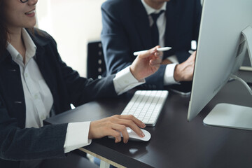 Two business colleagues having a discussion, working on computer during meeting at office. Businessmen planning and solution, working together, business collaboration