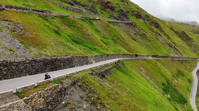 Drone shot of a motorbike driving over the Prato allo Stelvio Pass, Italy