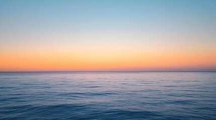 Fototapeta premium Peaceful ocean view during sunset with gradient sky transitioning from soft blue to warm orange, reflecting calm and natural beauty