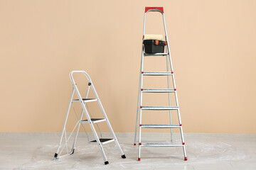 Maintenance ladders near beige wall