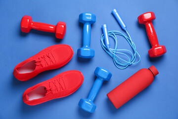 Sports equipment and water bottle on blue background, flat lay