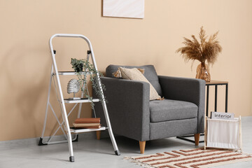 Interior of stylish room with armchair, stepladder and table