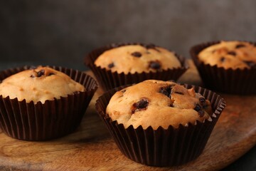 Delicious muffin with chocolate chips on table, closeup