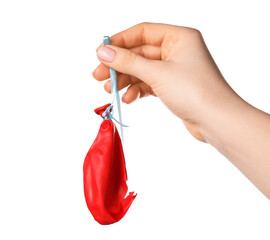 Woman holding popped red balloon on white background, closeup