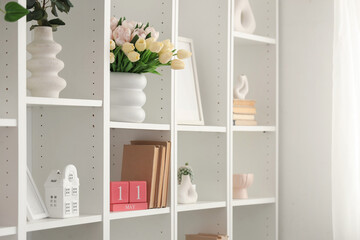 Shelf unit with tulips, books and decor for Mother's Day in room