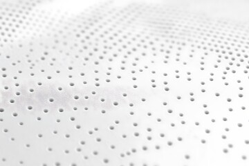 White perforated material background with small holes for breathability and ventilation