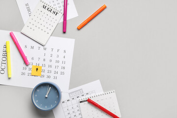 Calendars with alarm clock and markers on grey background with space for text