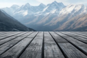 Wooden planks overlook a breathtaking, snow-capped mountain range under a hazy sky. © Isuru
