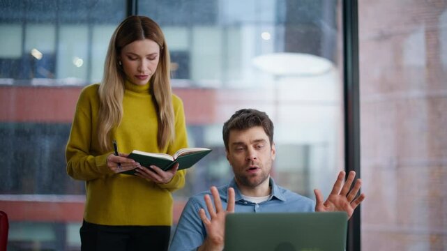 Serious supervisor checking work man intern making notes in notebook closeup.