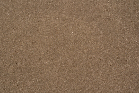 detalle de textura de suelo de arena caf&eacute; obscura de la playa