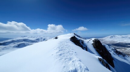 Snowy mountain ridge summit under a vibrant blue sky