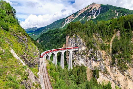 A Rhaetian Railway train crossing the Landwasser Viaduct at Grisons in Switzerland