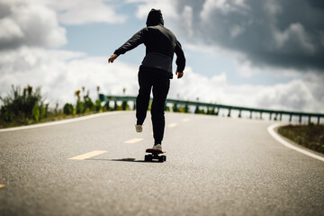 Skateboarder skateboarding on the mountain road