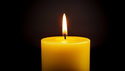 Lit yellow candle on dark background