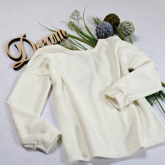 Elegant white long-sleeve top with delicate lace detailing at the neckline. Perfect for a dreamy, romantic look. Paired with dried flowers and a "Dream" sign for a whimsical vibe.
