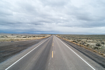 A long, empty road with a few trees in the distance