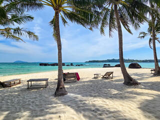Soft white sand stretches along the tranquil shores of Koh Mak and Koh Kham Island. Palm trees sway gently in the breeze, inviting beachgoers to unwind in this idyllic paradise in Thailand