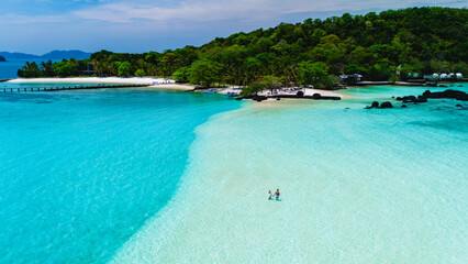 Breathtaking turquoise waters meet soft sandy beaches at Koh Kham Island in Thailand. Visitors enjoy the serene environment, perfect for relaxation and exploration of the natural beauty.