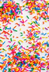 Rainbow sprinkles scattered on a white background, creating vibrant texture, celebration, festive, colorful sprinkles