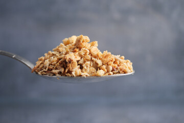 Healthy granola served on a silver spoon for a nutritious breakfast