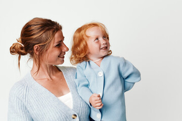 Mother and baby in light blue cardigan sweater embracing each other with love and warmth